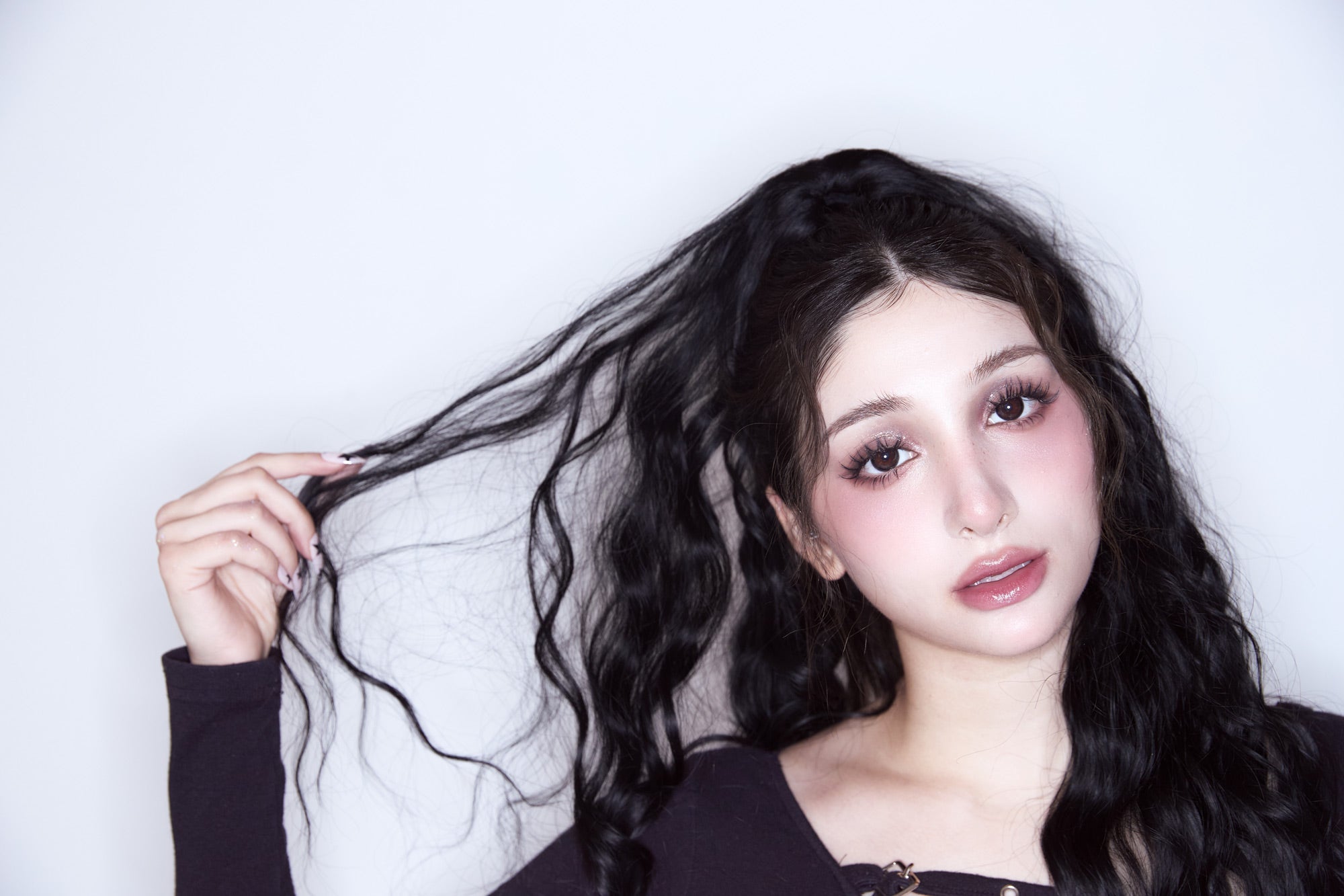 Frau mit langen schwarzen Harren mit weißem Hintergrund und Kontaktlinsen
